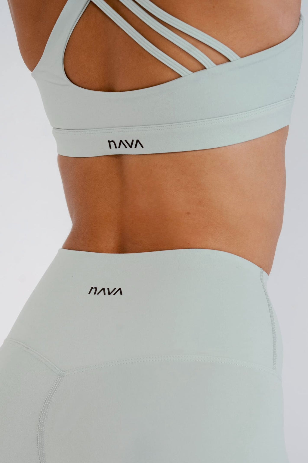Light green sports bra and leggings with 'Nava' branding on a white background