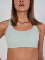 Light blue sports bra worn by a person on a plain background