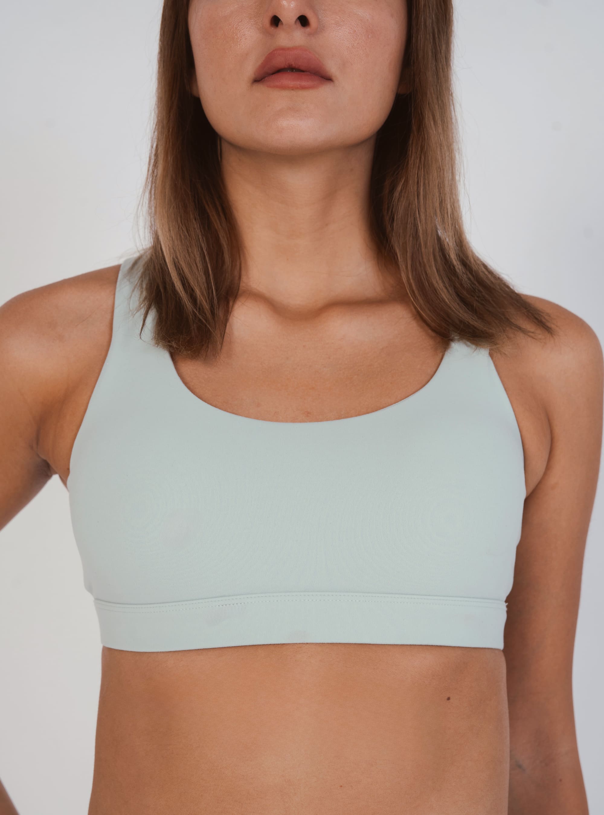Light blue sports bra worn by a person on a plain background