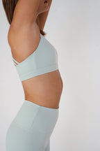Light blue sports bra and leggings on a plain background