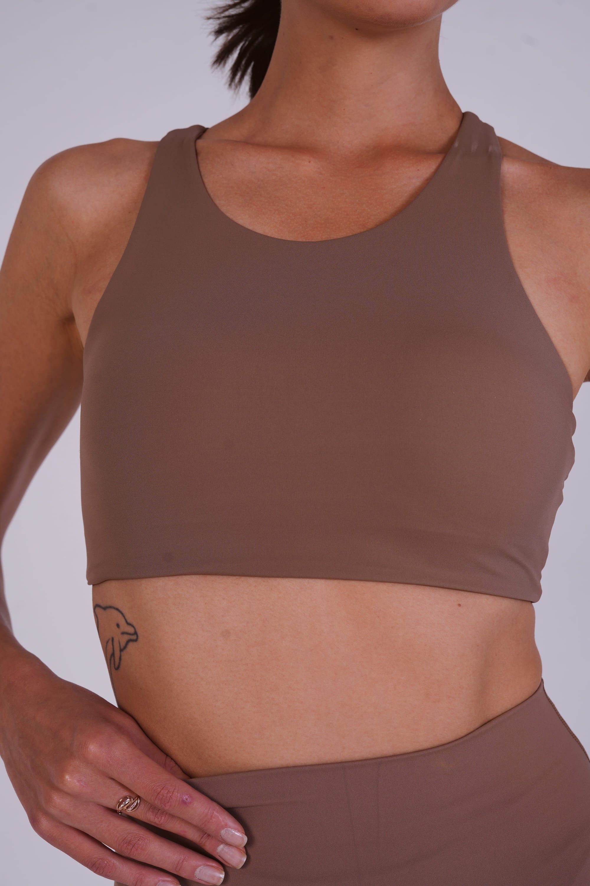 Brown sports bra worn by a person on a plain background