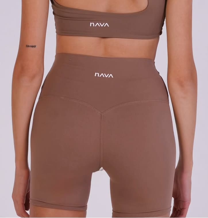 Brown sports bra and leggings set with 'NAVA' branding on a white background