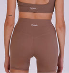 Brown sports bra and leggings set with 'NAVA' branding on a white background