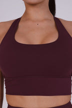 Maroon sports bra worn by a person on a white background