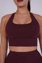 Maroon sports bra and leggings worn by a person on a plain background