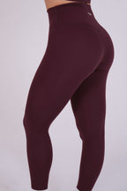 Maroon leggings worn by a person on a white background