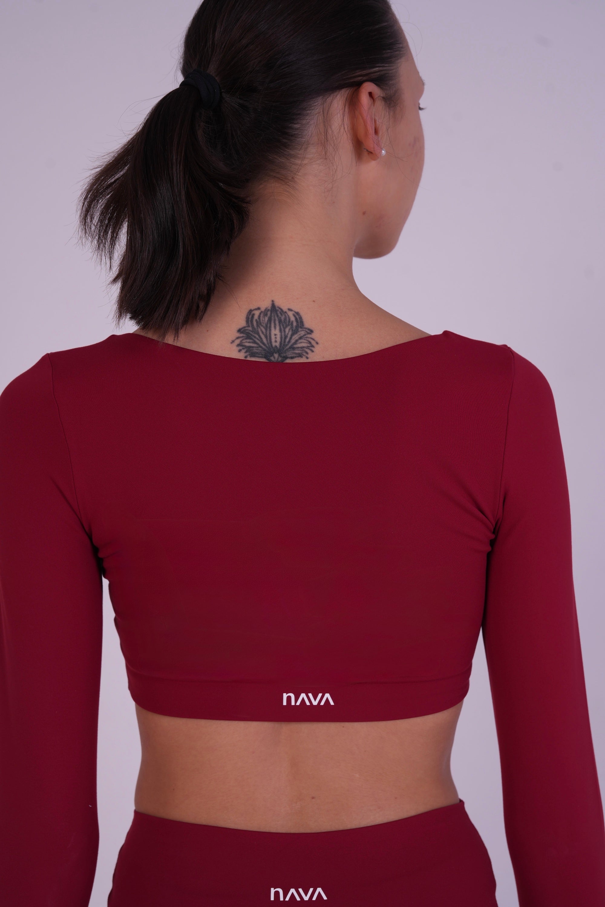 Back view of the NAVA Fire Opal bra top, highlighting the deep red gemstone tone and smooth long-sleeve fit.