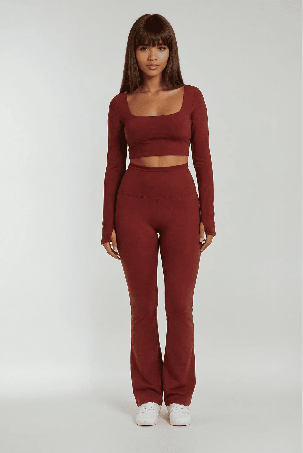 Person wearing a maroon long-sleeve top and pants on a white background