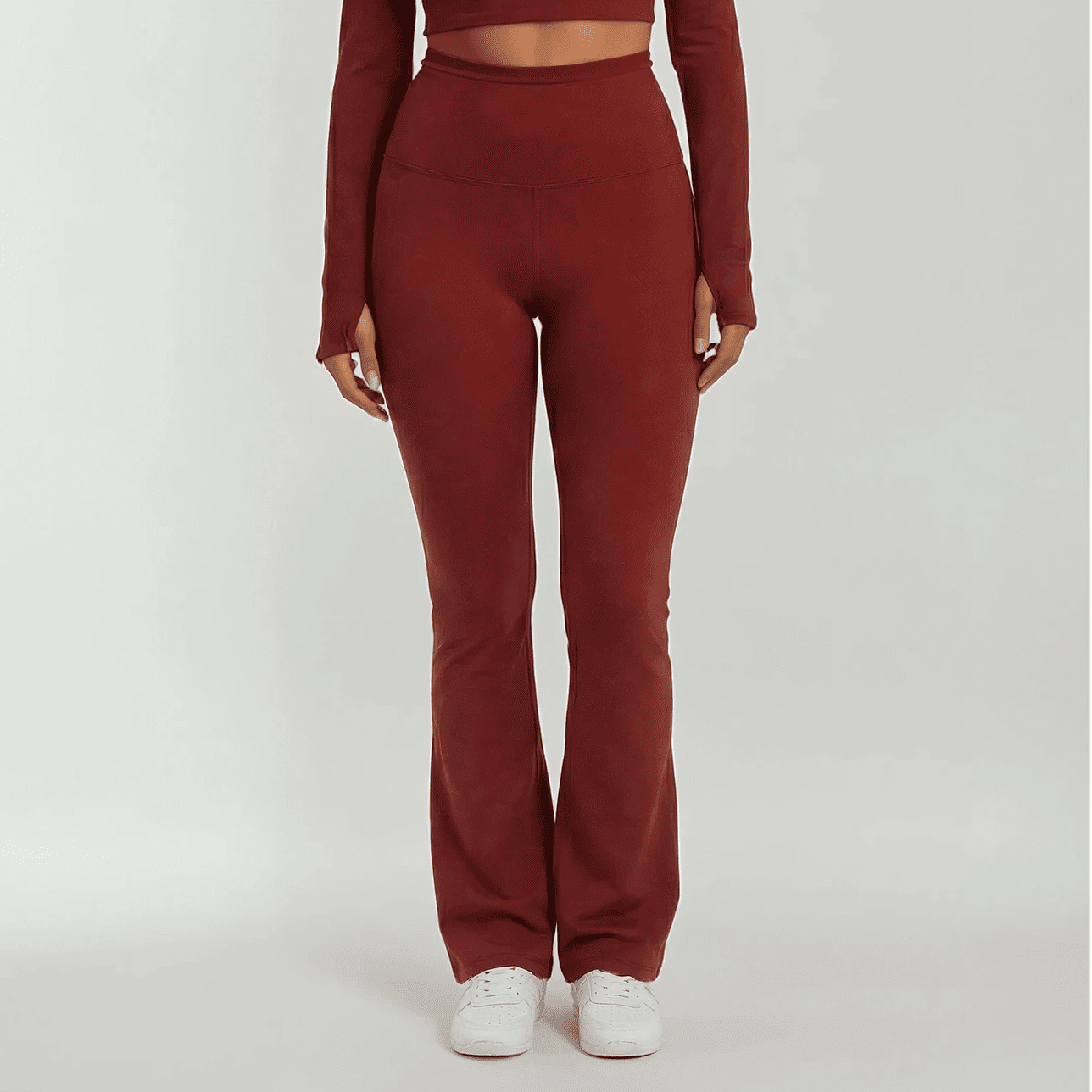 Maroon outfit with high-waisted pants and long-sleeve top on a white background