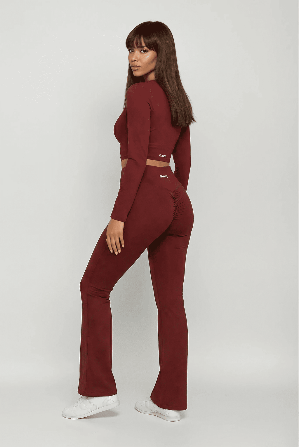 Woman wearing a burgundy tracksuit on a white background