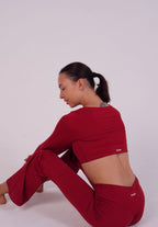 Person wearing a red outfit sitting on a white background