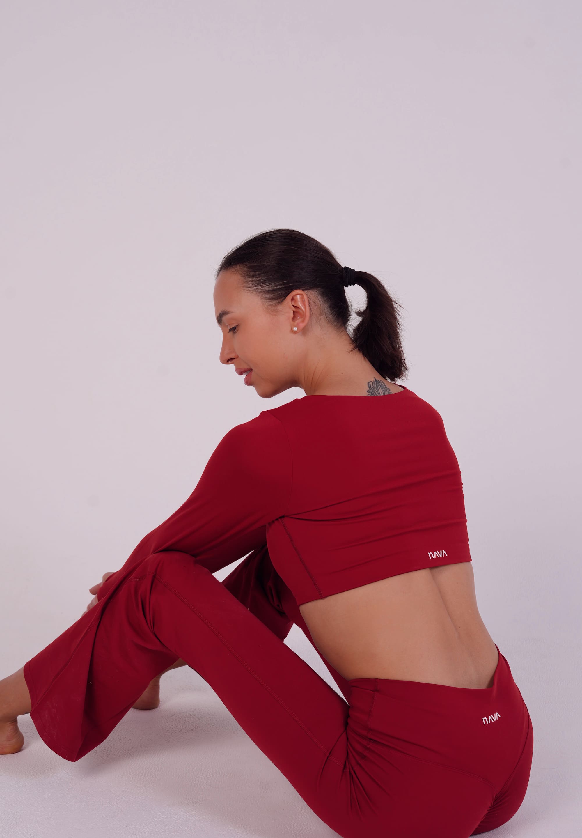 Person wearing a red outfit sitting on a white background