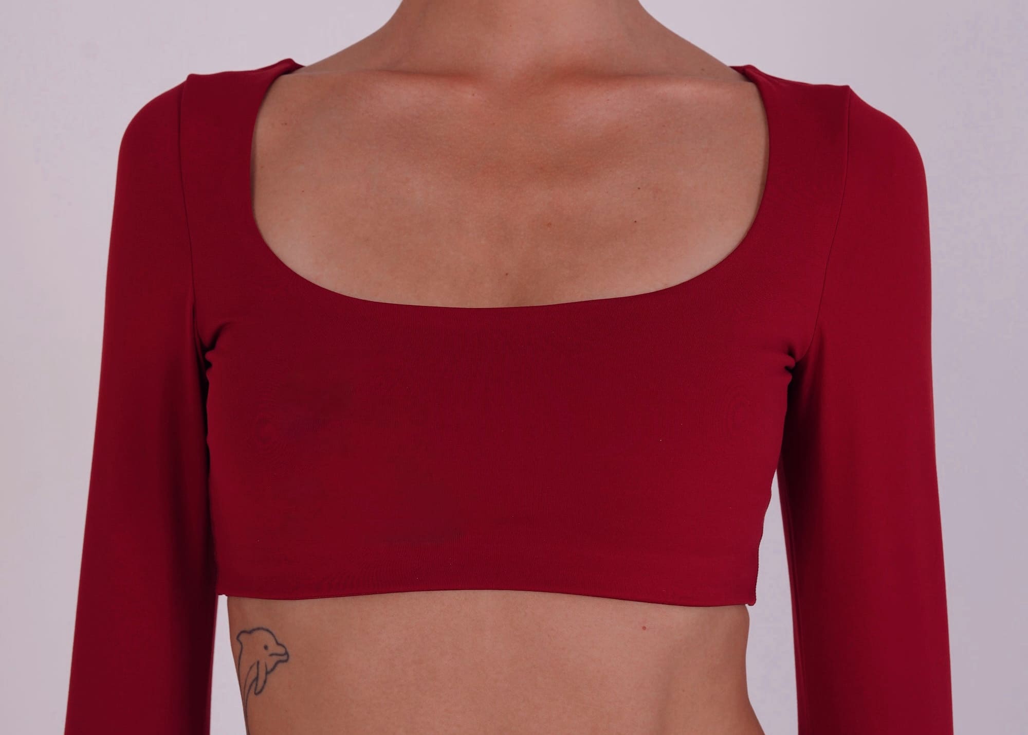 Red long-sleeve crop top on a plain background