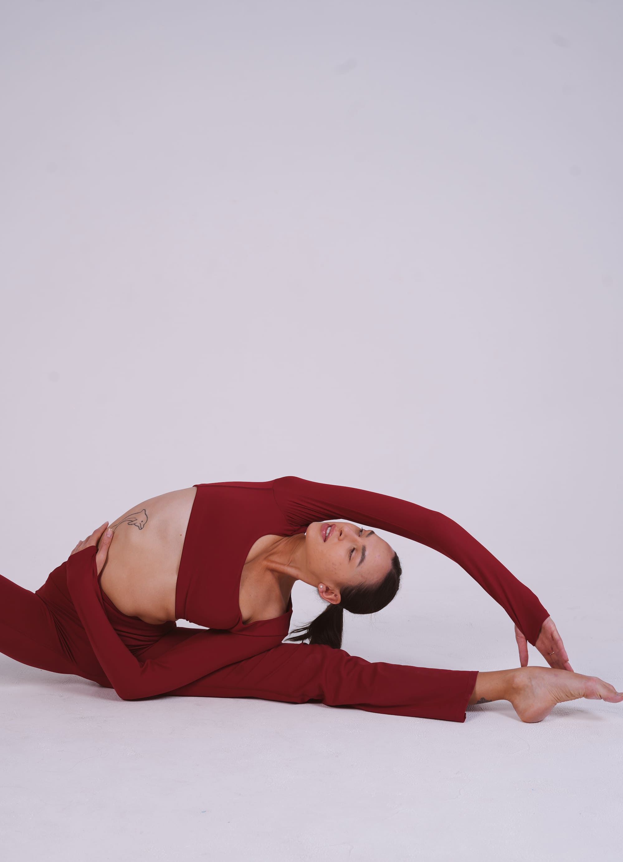 Woman stretching in Fire Opal flare leggings and matching yoga top