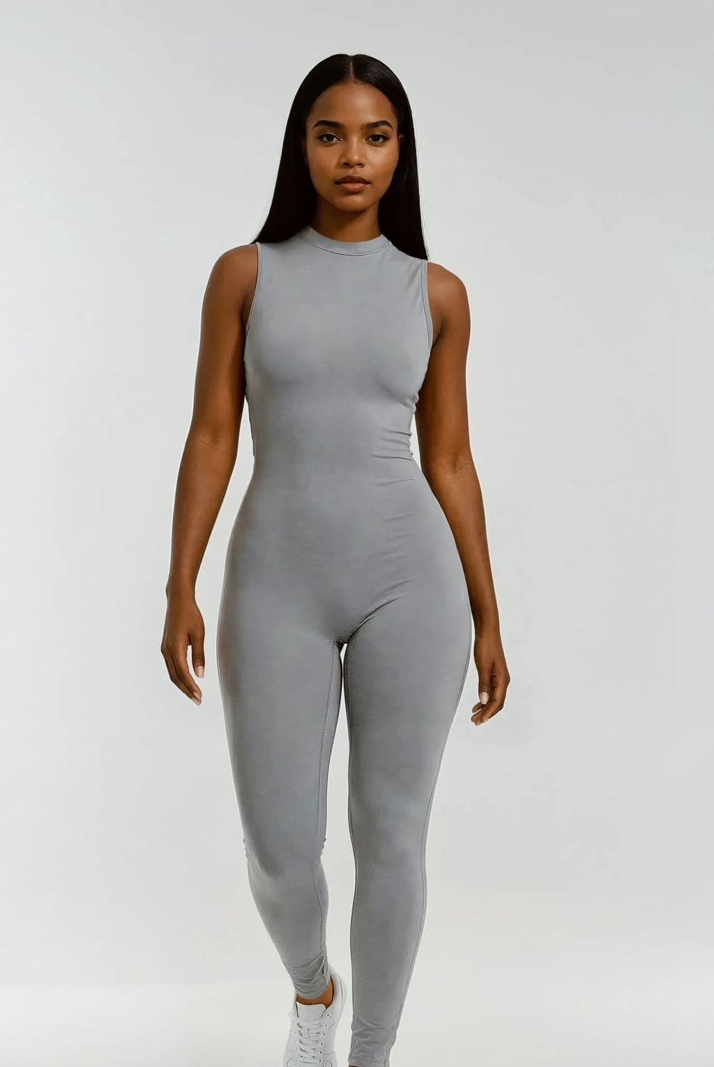 Woman wearing a gray sleeveless jumpsuit on a white background