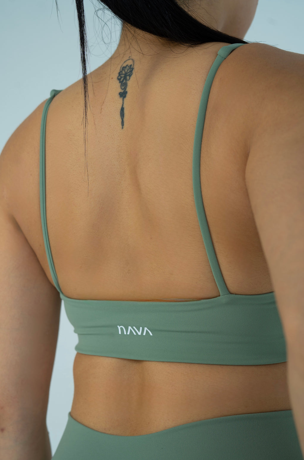 Back view of the NAVA Horizon Jade Bra Top featuring thin straps and minimalist logo detail