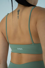 Back view of the NAVA Horizon Jade Bra Top featuring thin straps and minimalist logo detail