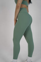 Green leggings worn by a person on a plain background