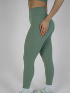 Green leggings worn by a person on a plain background