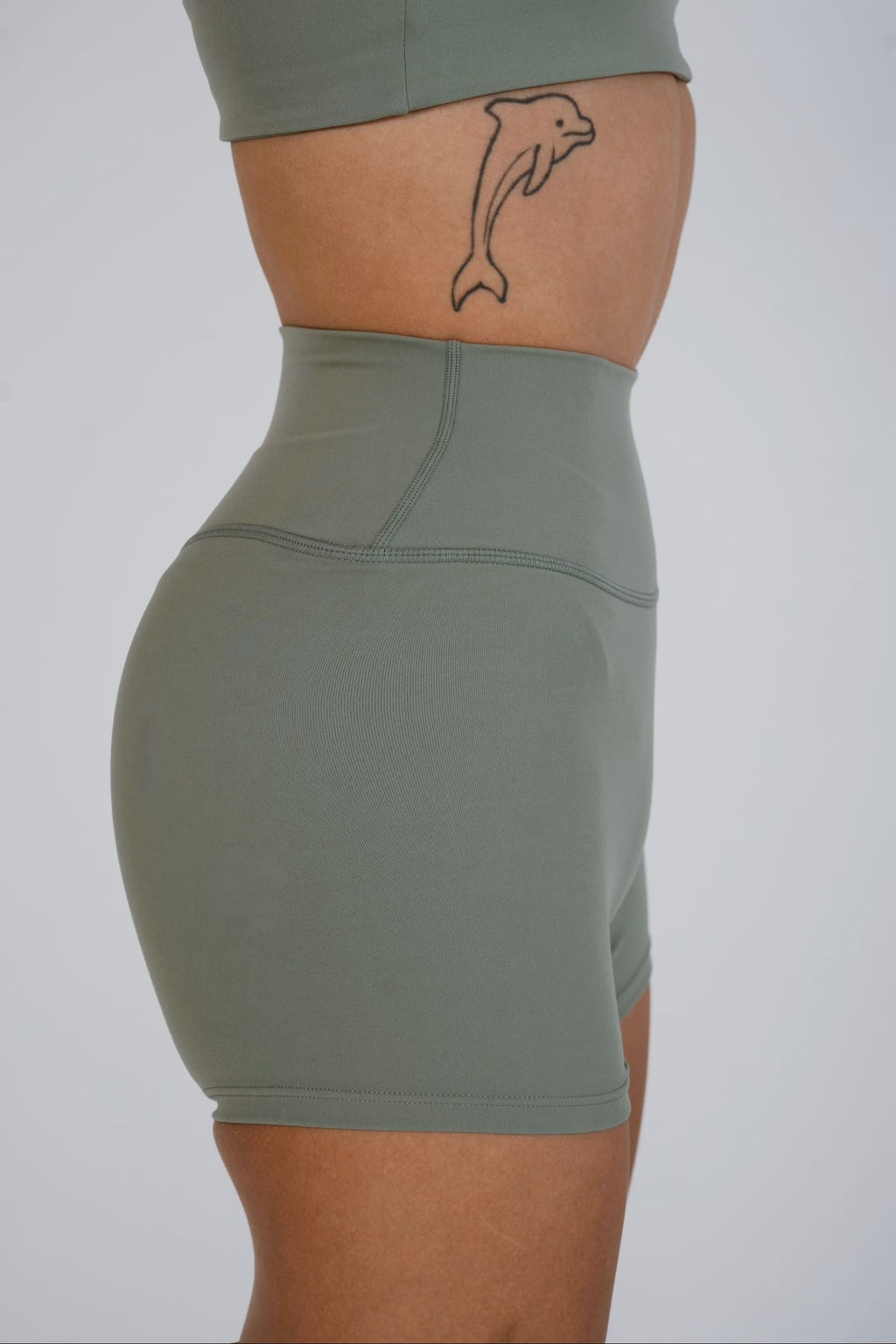 Person wearing a green athletic skirt on a plain background