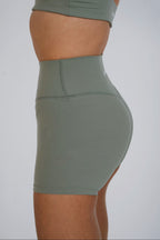 Green athletic shorts worn by a person on a plain background