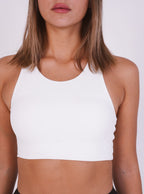 White crop top worn by a person on a white background