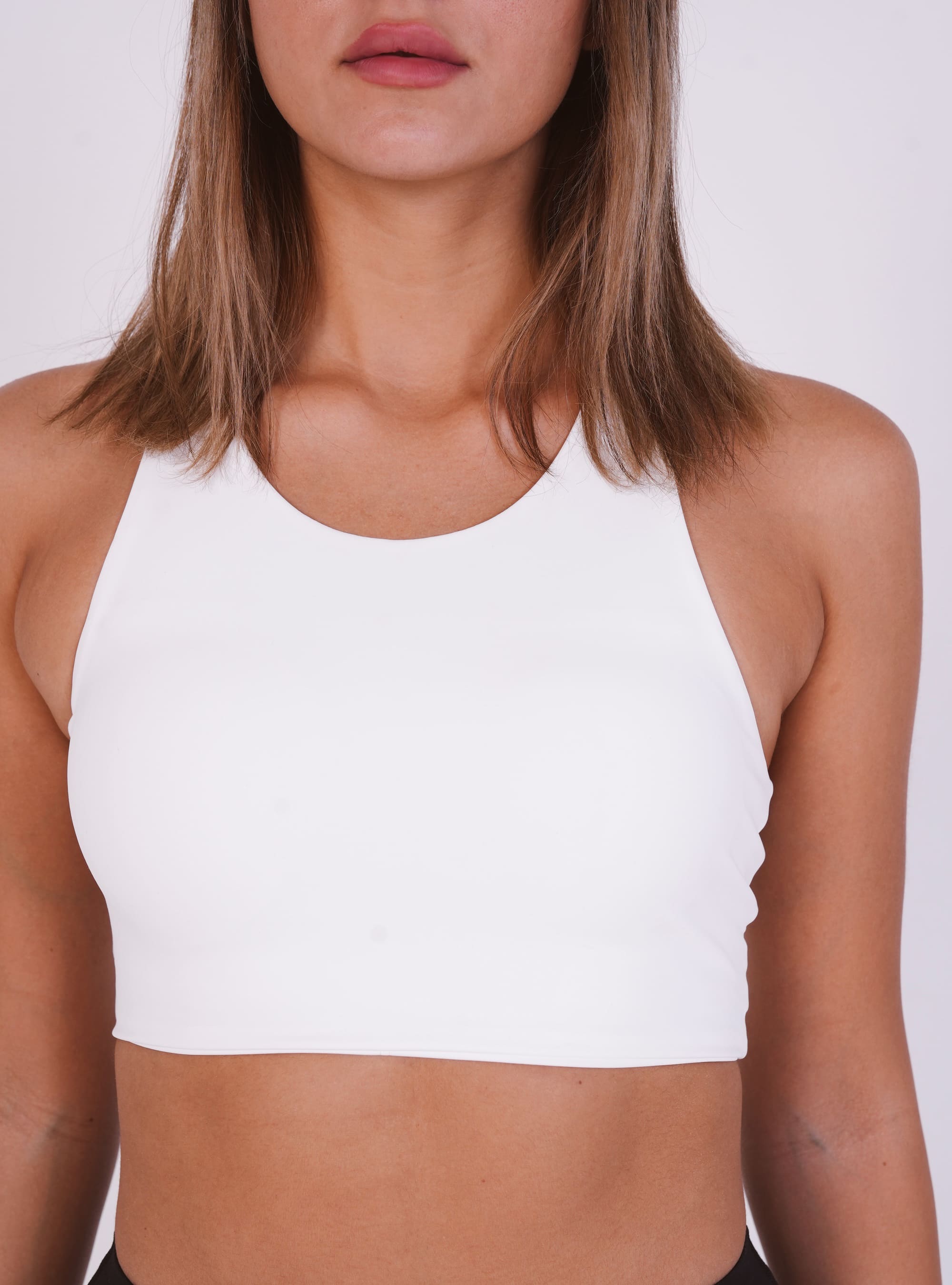 White crop top worn by a person on a white background