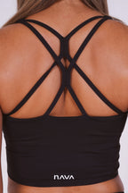 Black sports bra with criss-cross straps on a white background