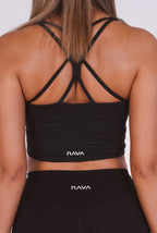 Black sports bra and leggings with 'NAVA' branding on a plain background