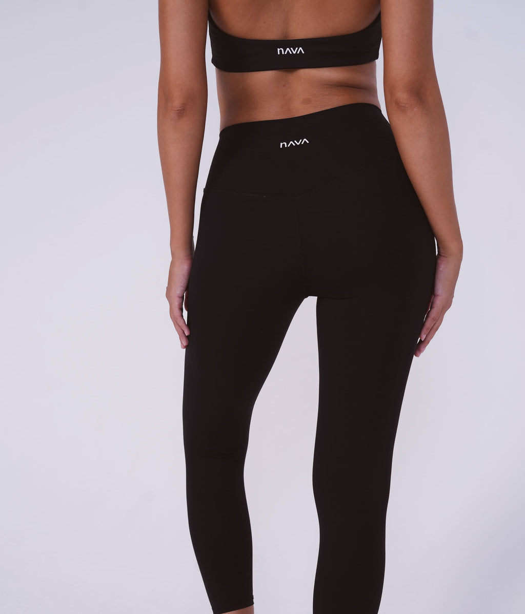Person wearing black leggings with 'Nava' branding on a white background