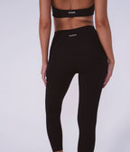 Person wearing black leggings with 'Nava' branding on a white background