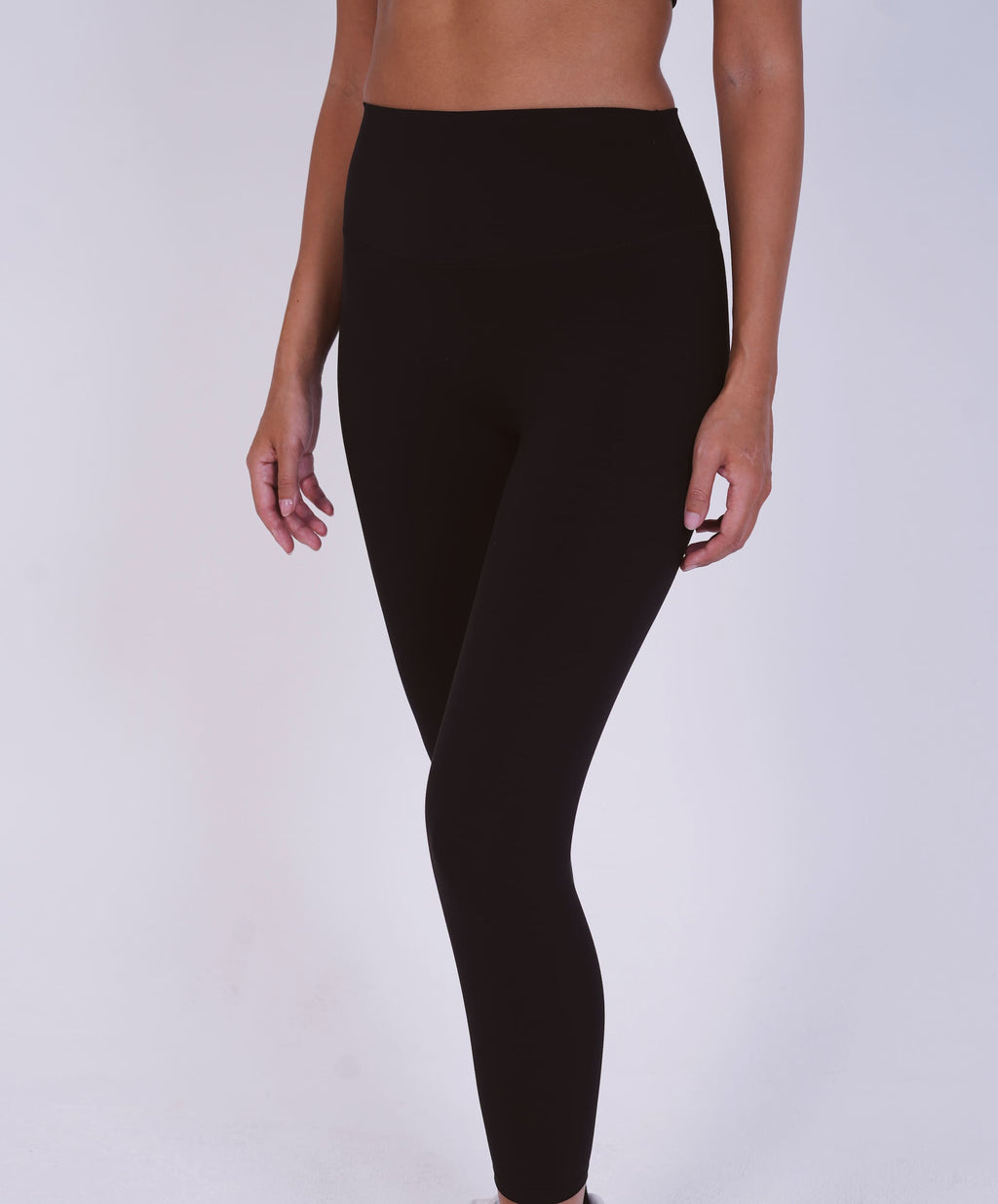 Person wearing black leggings on a white background
