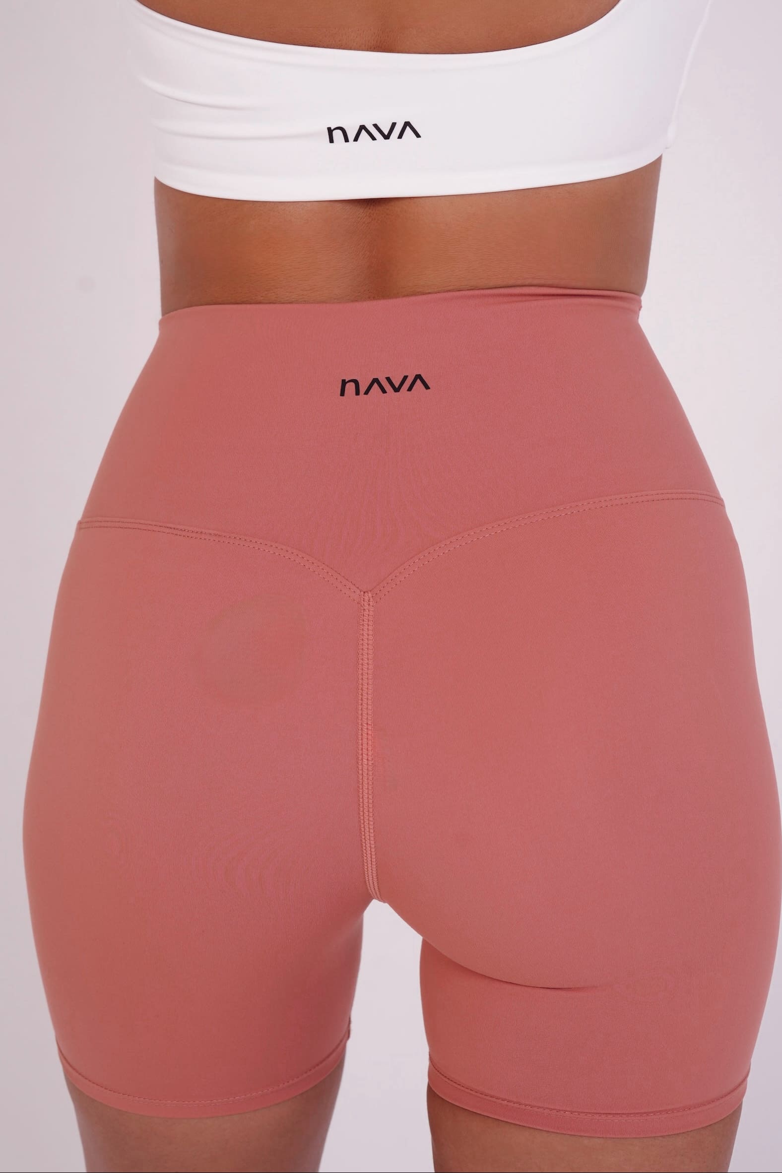 Pink leggings with 'Nava' branding on a white background