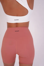 White sports bra and pink shorts with 'Nava' branding on a white background