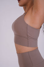 Brown sports bra and leggings set on a plain background