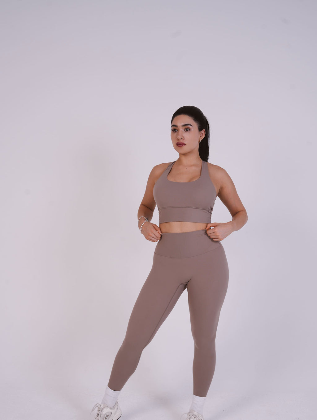 Woman wearing a brown athletic outfit on a white background