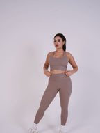 Woman wearing a brown athletic outfit on a white background