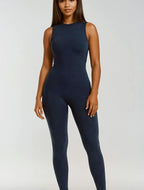 Person wearing a navy blue jumpsuit on a white background