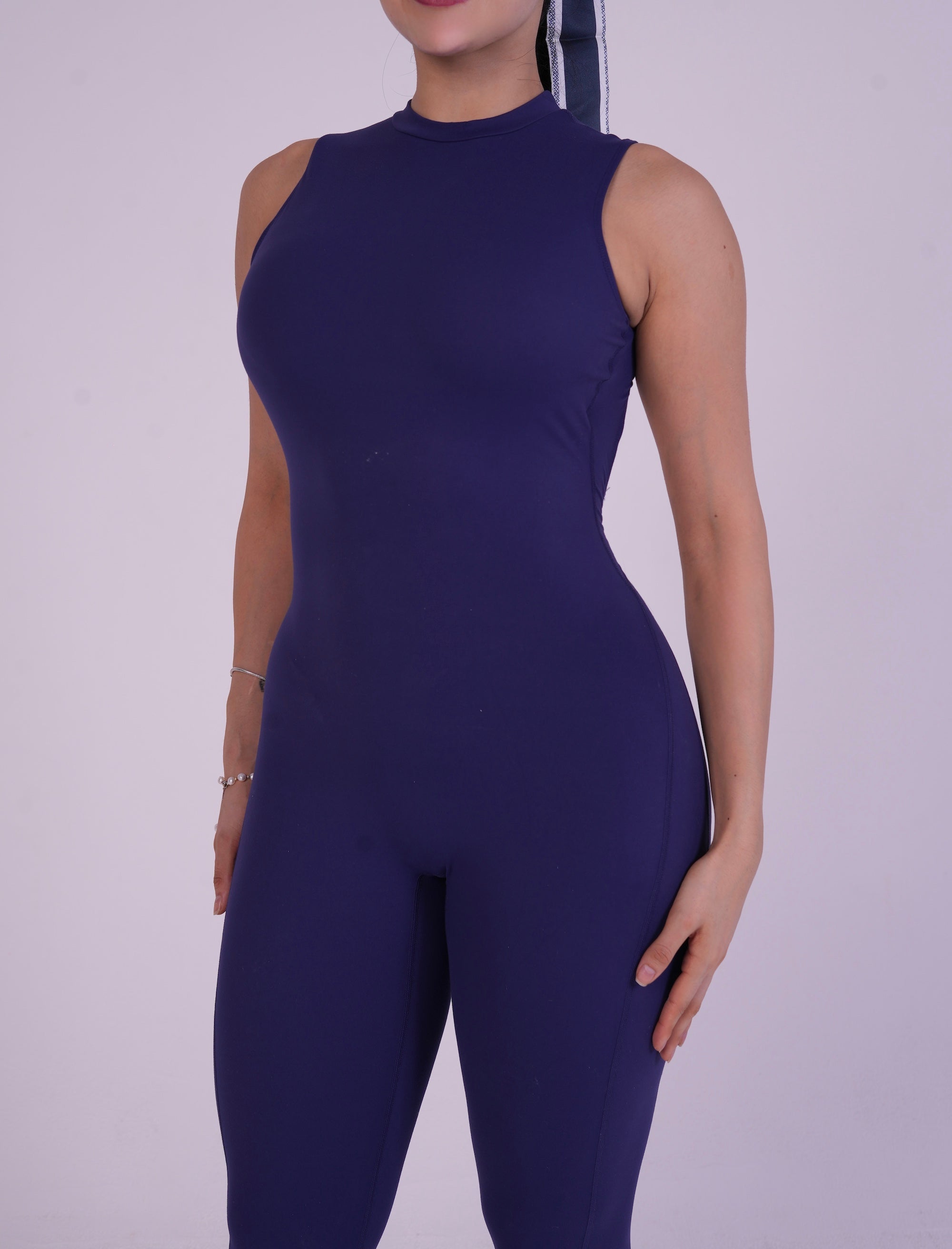 Front view of the NAVA Sapphire Jumpsuit, showcasing the deep blue gemstone tone and sleek full-body activewear fit.