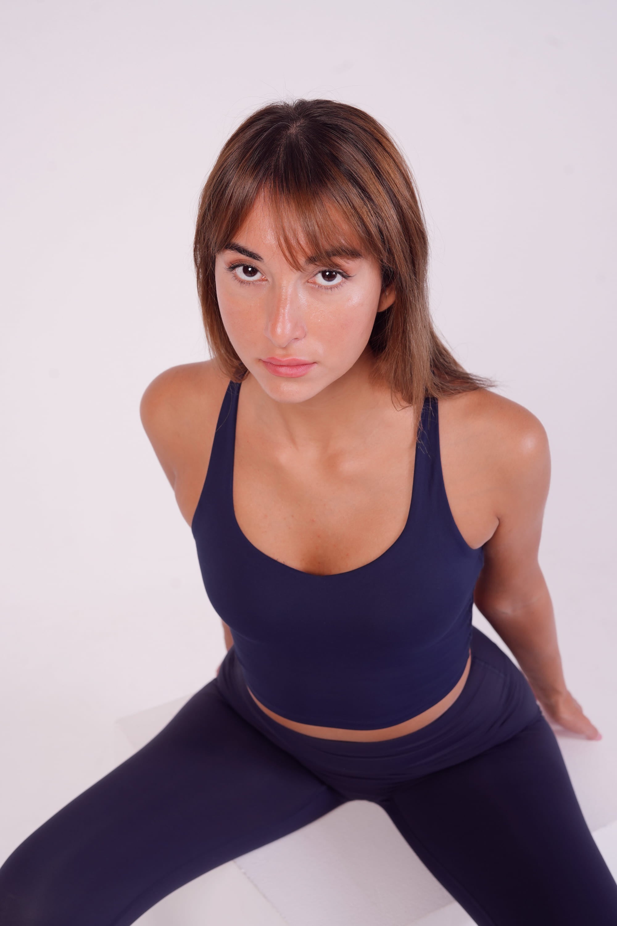 Woman wearing a navy blue athletic outfit on a white background