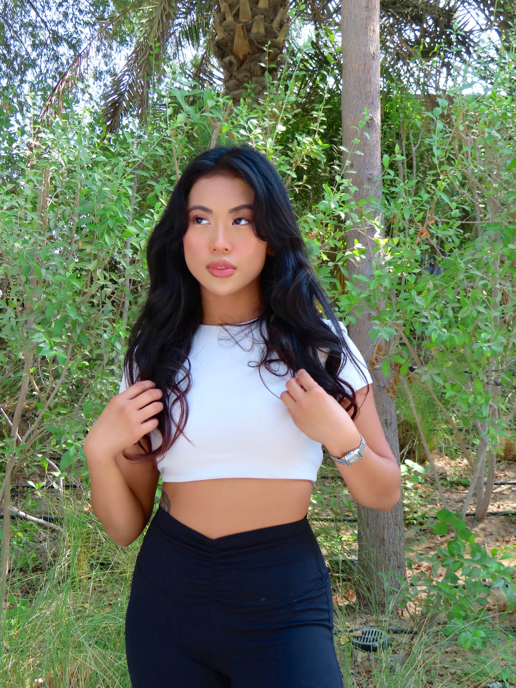 NAVA White Quartz Crop Top Outdoor Standing Pose – women's activewear short sleeve top with black leggings